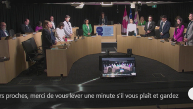 Municipal council meeting in progress with representatives standing around a U-shaped desk; Laval logo visible in the foreground.