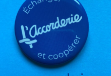 Blue circular badge with L'Accorderie script and the French motto Échanger et coopérer; website www.accorderie.ca below.