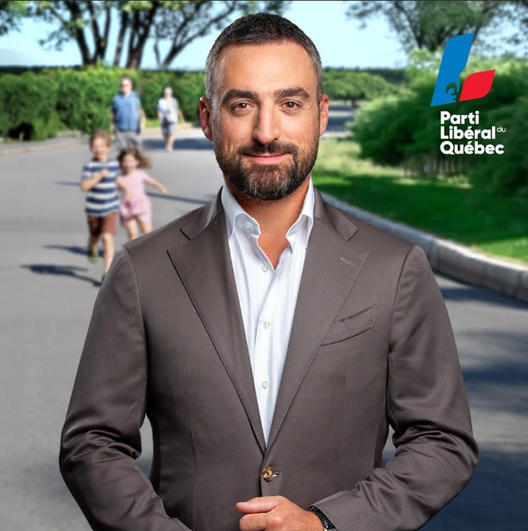 Portrait of a man in a gray suit facing the camera in an outdoor park setting, with the Parti Libéral du Québec logo visible on the right.